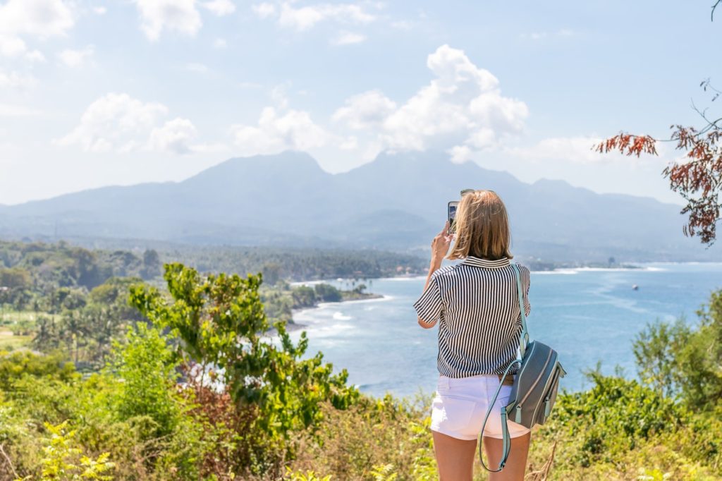 woman taking photo of mountains